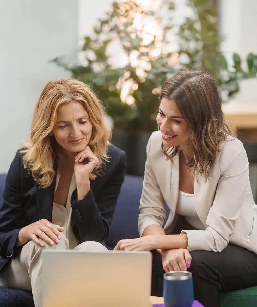 Two businesswomen reviewing something together on a laptop